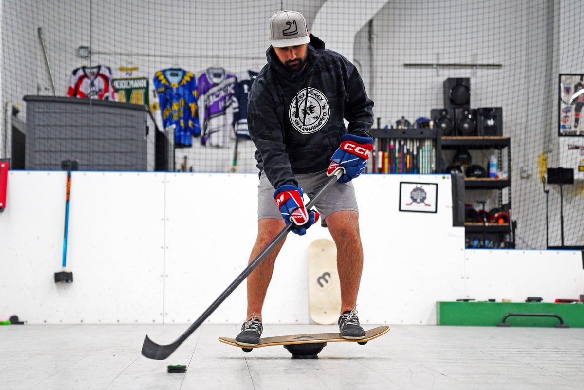 Man training hockey stickhandling while balancing on a Whirly Board