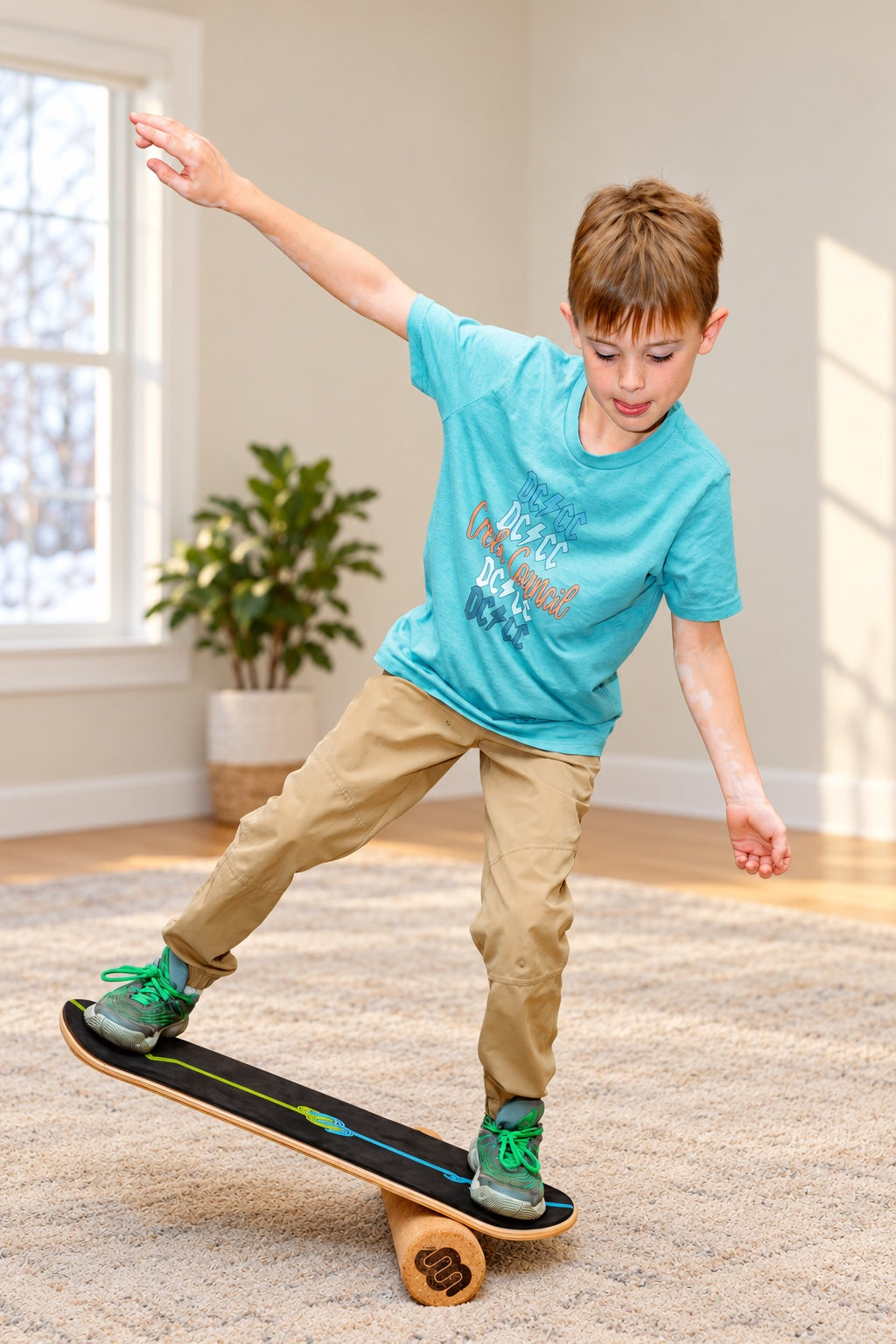 A boy balances with one arm up on a Whirly Complete set up on the Roller