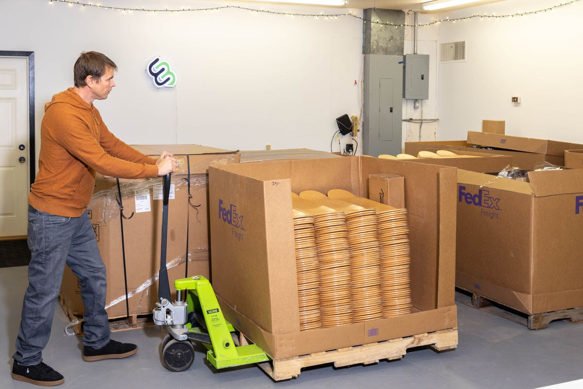 Erik moving pallets of boxed boards