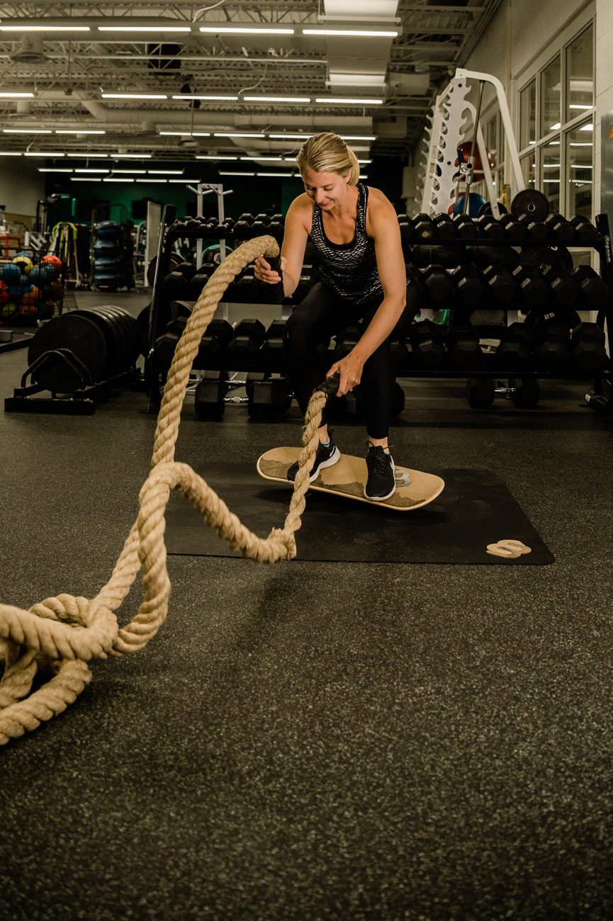 Woman doing battle ropes on a Whirly Board