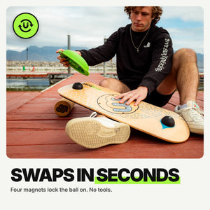 Swaps in seconds: rider lifting the green MagLock ball off the Whirly Complete deck on a dock