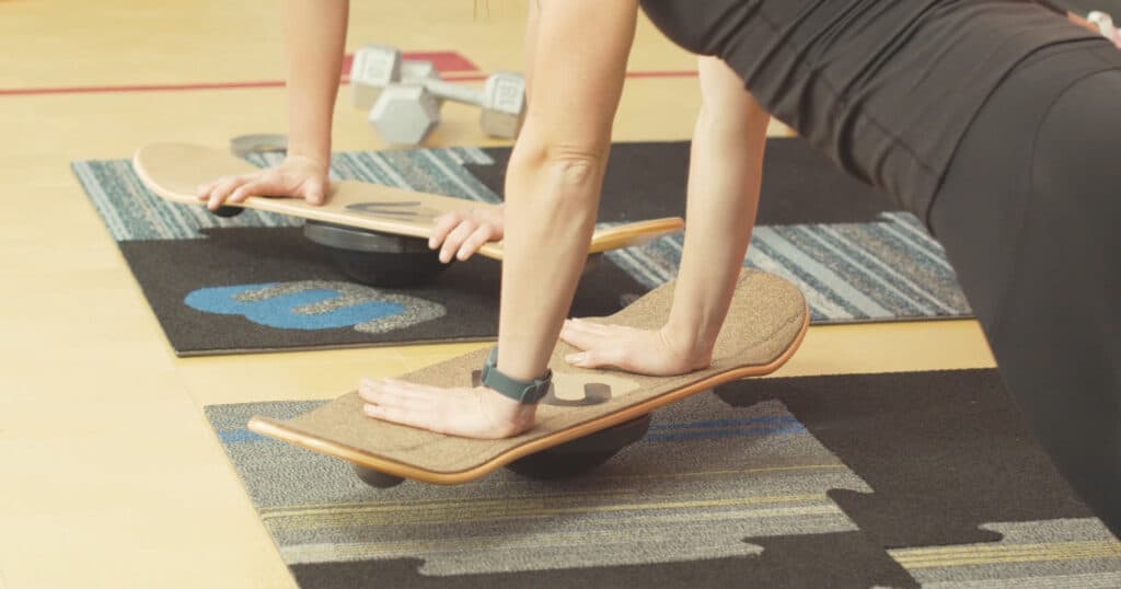 Two people doing balance board workouts.