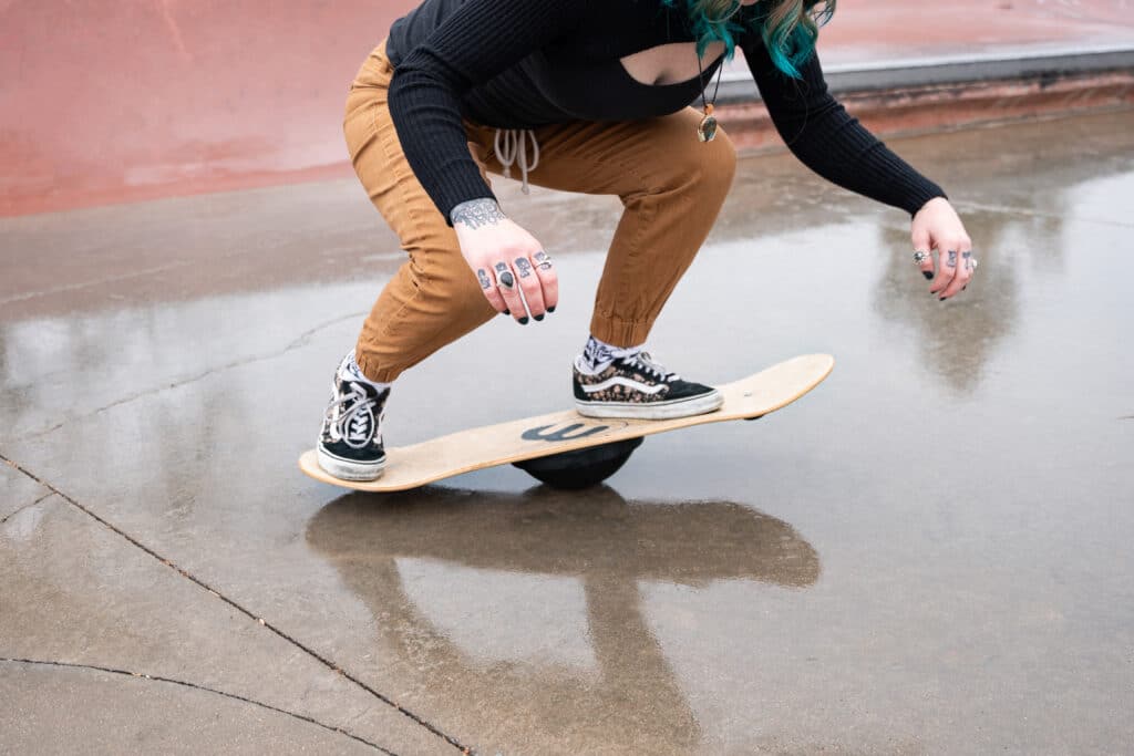 Woman performs tricks on a Whirly Board fitness balance board